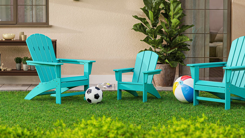 POLYWOOD Nautical Adirondack Chairs and a Kids Nautical Adirondack Chair in Aruba sit on a lawn with children’s toys.