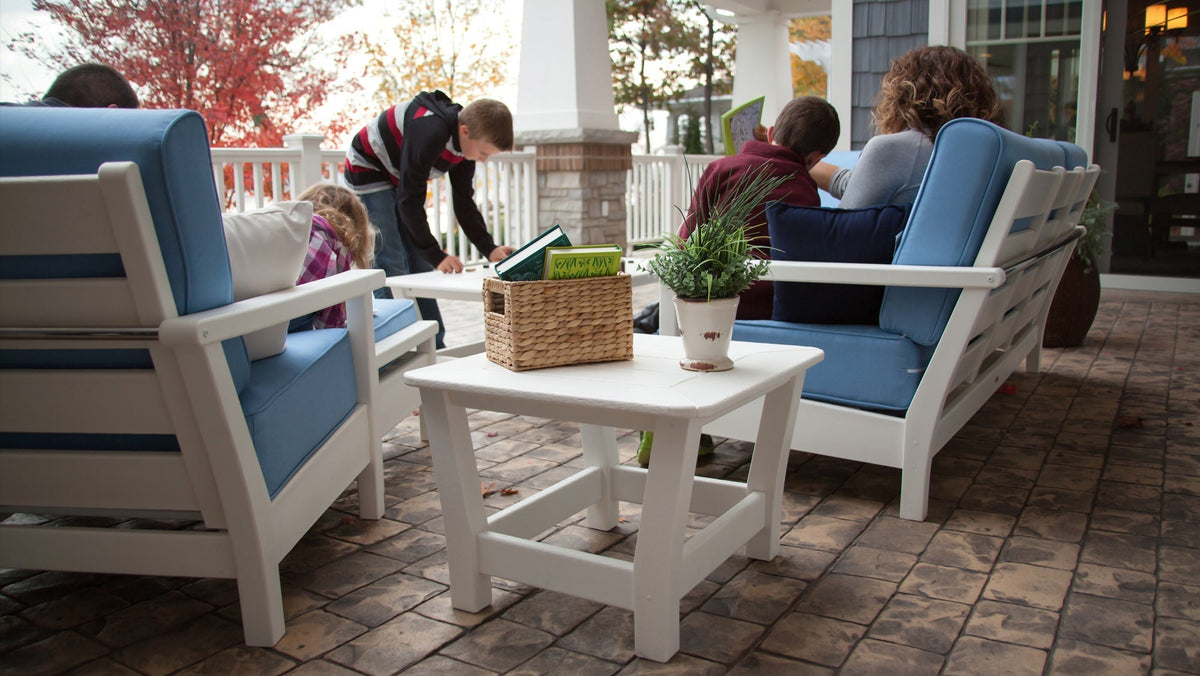 A family sits out on a brick patio on a POLYWOOD Harbour 5 Piece Deep Seating Set in White and Sky Blue.