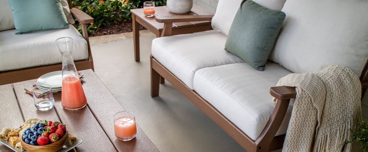 A POLYWOOD Braxton 5 Piece Deep Seating Set in Teak with Natural Linen cushions sits on a patio.