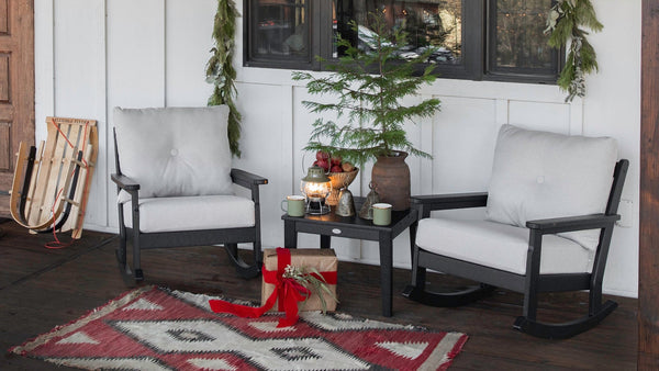 A POLYWOOD Vineyard 3-Piece Deep Seating Rocker Set in Black and Natural Linen sits on a rustic porch with holiday decor. 