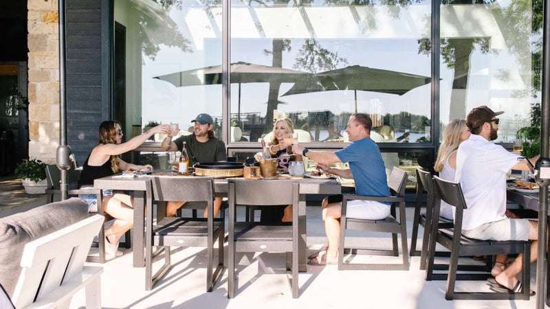 Friends dining outdoors on a modern POLYWOOD patio set.