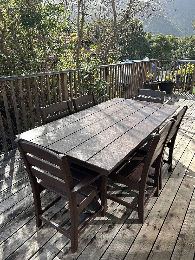 A POLYWOOD Lakeside 7 Piece Farmhouse Dining Set with Trestle Legs in  Mahogany sits on a balcony deck with mountain views.