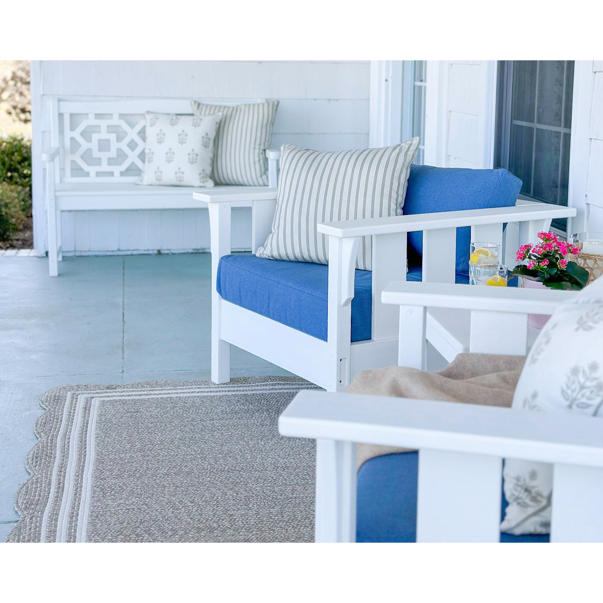 outdoor seating with white frames and blue cushions on patio