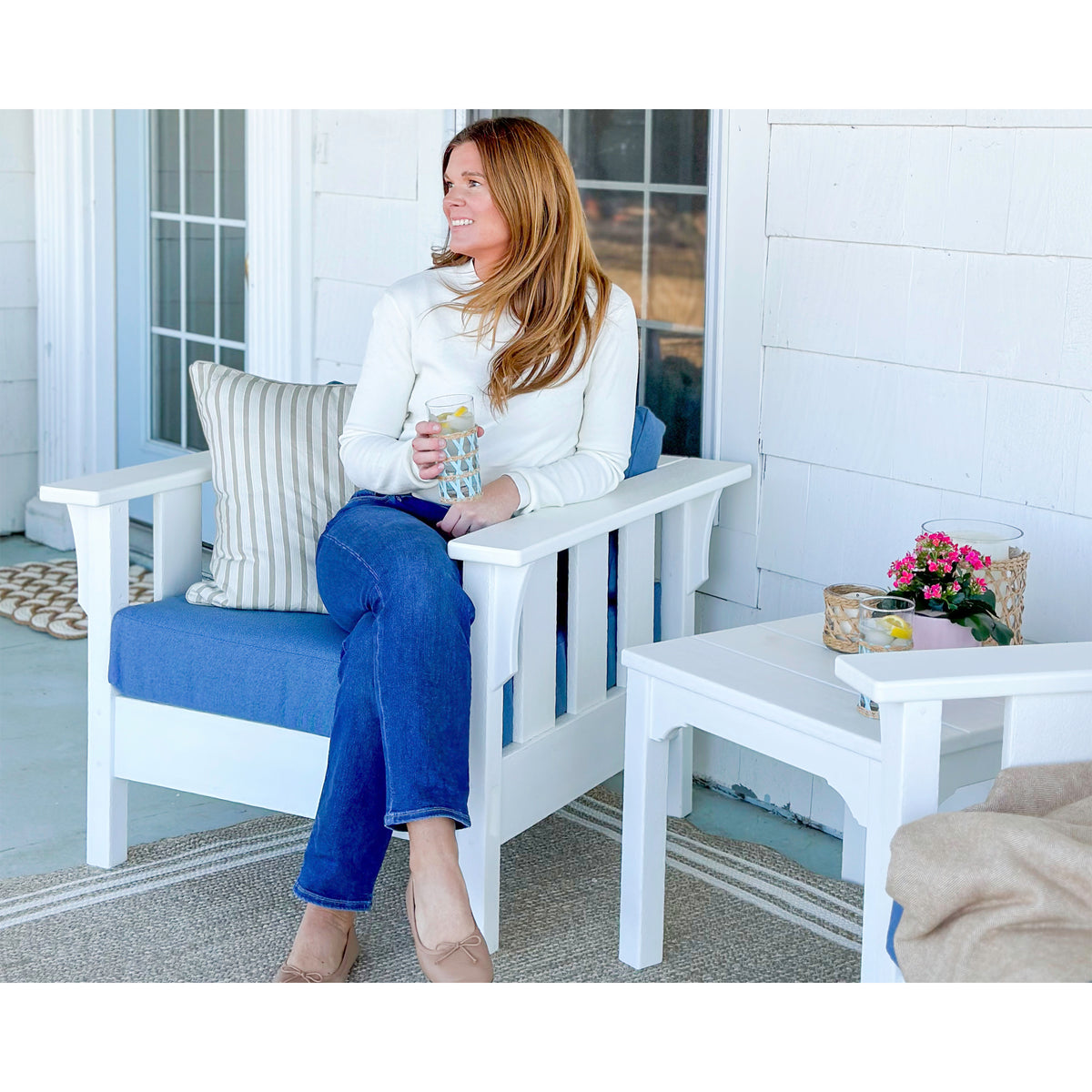 woman sitting on white outdoor chair in blue cushions